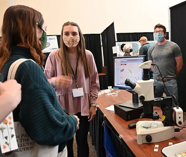 Doctoral student and nematologist Alison Coomer fields questions from the crowd. At far right is scientist Rob Blundell, who assisted. (Photo by Kathy Keatley Garvey)