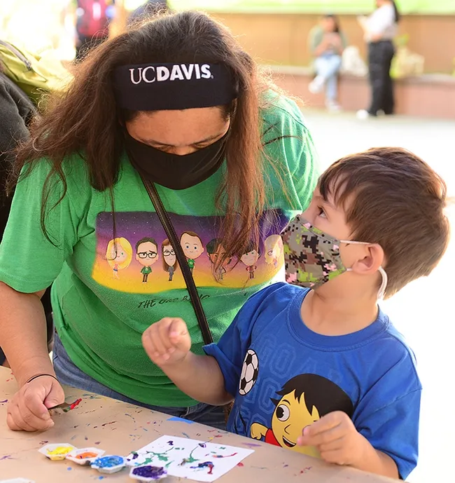 Hudson Carr, 4, gets some helpful tips from his mother, UC Davis alumnus Angie Velazquez of Los Angeles. (Photo by Kathy Keatley Garvey)