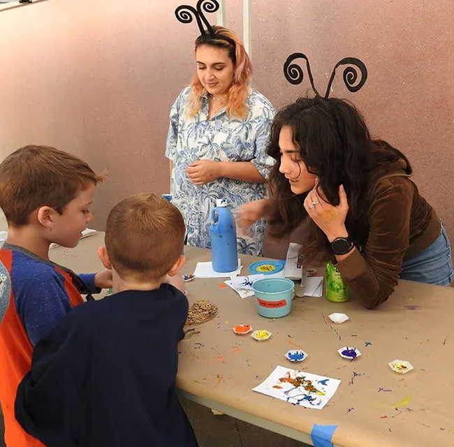 UC Davis undergraduate student Summer Calvache (left) and graduate student Elizabeth Slagboon assist the young artists. (Photo by Kathy Keatley Garvey)