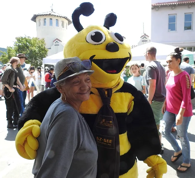 Wendy Mather, program manager of the California Master Beekeeper Program, donned a bee costume to greet guests. Luz Torres (pictured) of Woodland adored the bee. (Photo by Kathy Keatley Garvey)