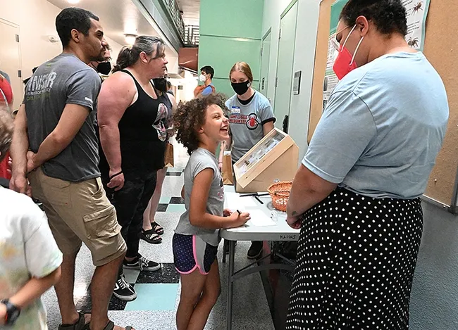 Alexis Rainwater, 8, of Woodland, delights in chatting with Iris Bright of the Jason Bond lab. "Alexis likes spiders," her mother said. "And she's a model." Bright will be a first-year doctoral student in the fall. (Photo by Kathy Keatley Garvey)