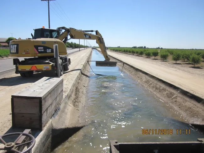 Removing seeds from irrigation canal near Tulare, CA using chaining