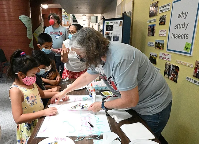 Entomologist Fran Keller assists a participant at the American Arachnological Society station on sticky vs. non-sticky silk. (Photo by Kathy Keatley Garvey)