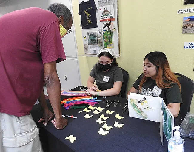 UC Davis students Danielle Sion and Amberly Hackmann staff the felt dogface butterfly table.(Photo by Kathy Keatley Garvey)