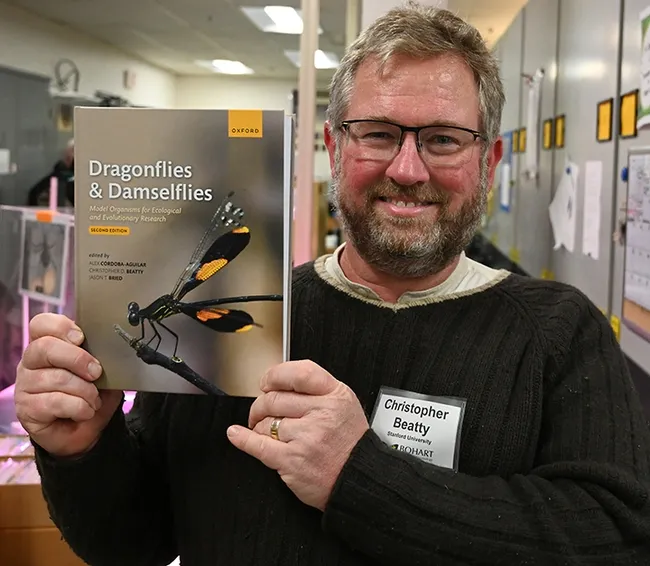 Christopher Beatty, a visiting scholar in the Program for Conservation Genomics at Stanford University, co-edited this newly published book, "Dragonflies and Damselflies: Model Organisms for Ecological and Evolutionary Research," second edition. Fresh from the printers, it was among the dragonfly books displayed at the open house. (Photo by Kathy Keatley Garvey)