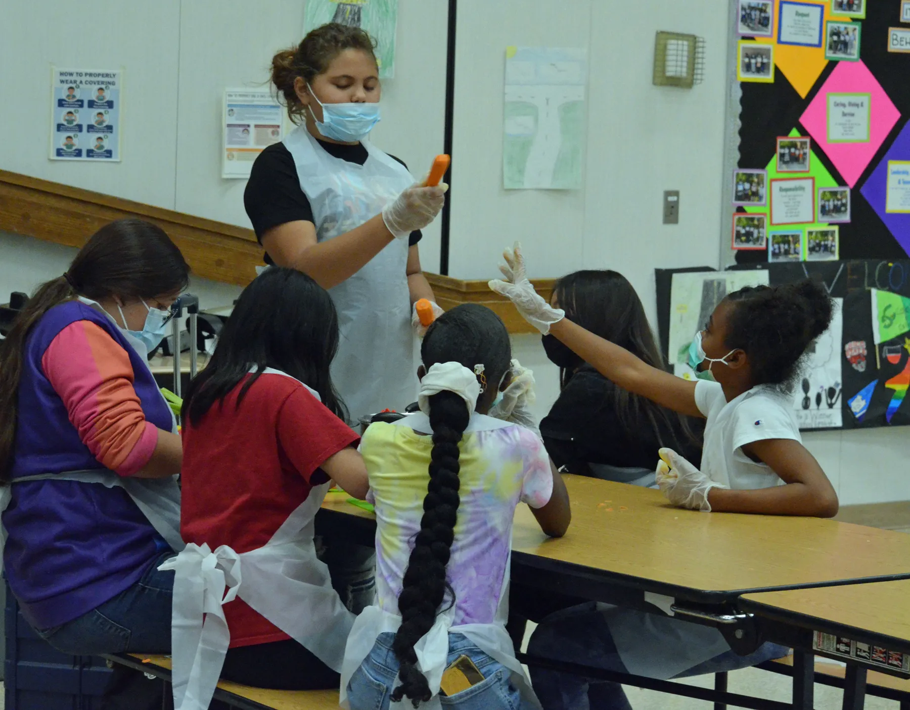 Students of cooking academy looking at carrots