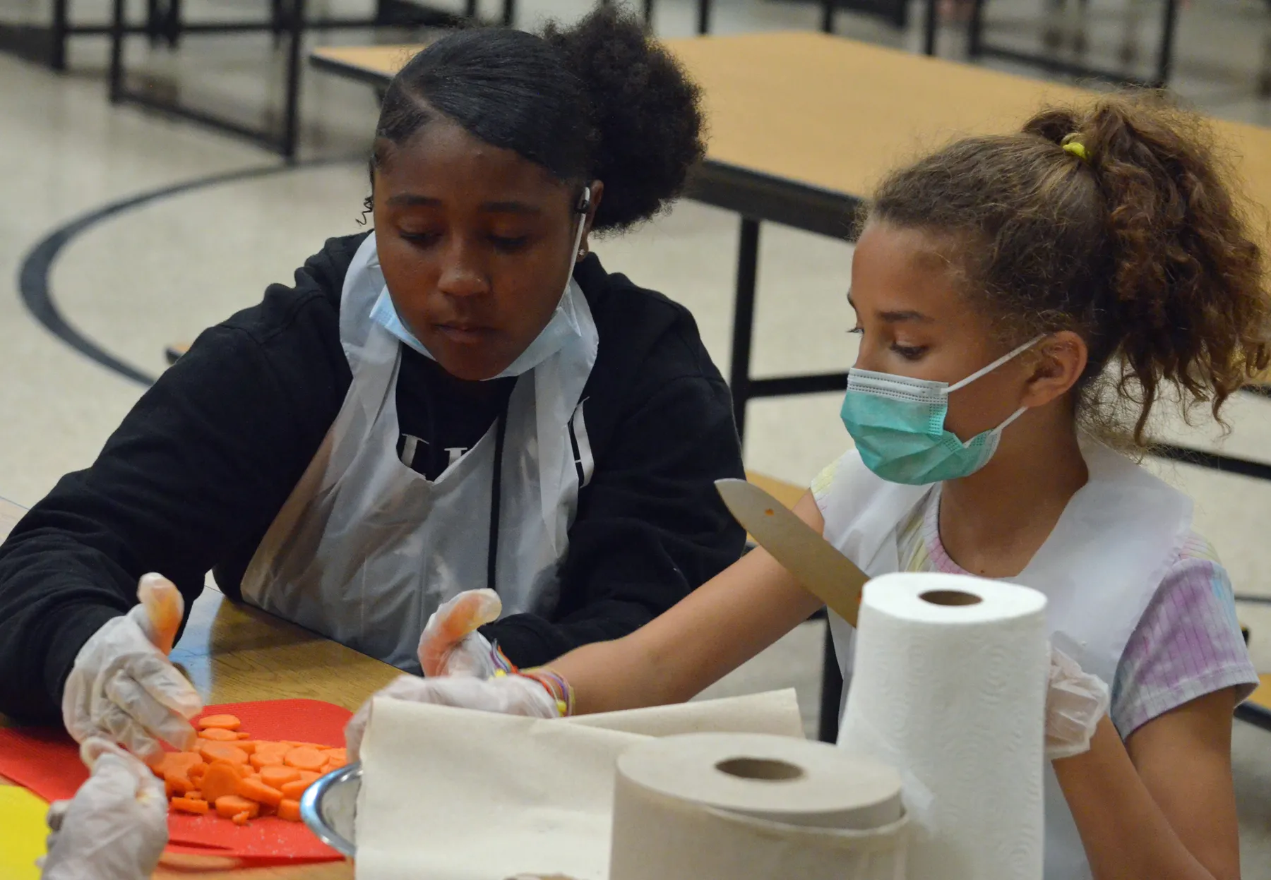 Cooking Academy students cutting up carrots