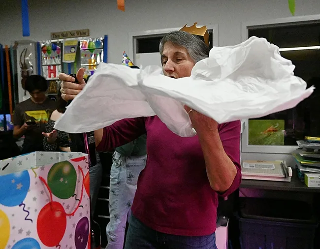 It's a wrap! "Birthday gal" Lynn Kimsey unfurls the wrapping of a gift. (Photo by Kathy Keatley Garvey)