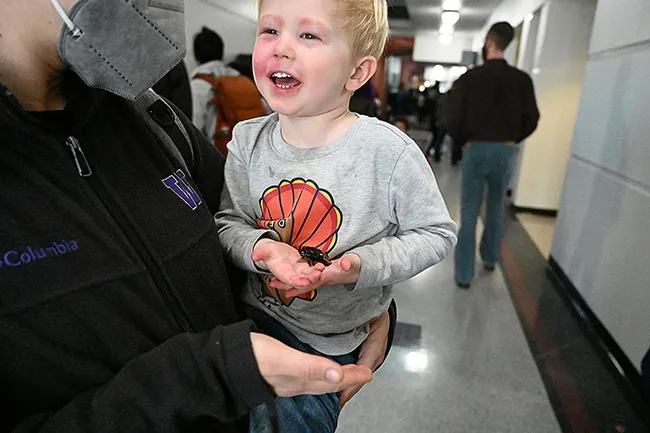 Finn Jensen beams in delight as he holds the Madagascar hissing cockroach. (Photo by Kathy Keatley Garvey)