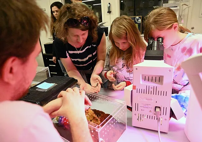 Kim Crawford of Cameron Park and her daughter, Emma, 10, hold millipedes. At left (foreground) is doctoral candidate Xavier Zahnle. (Photo by Kathy Keatley Garvey)