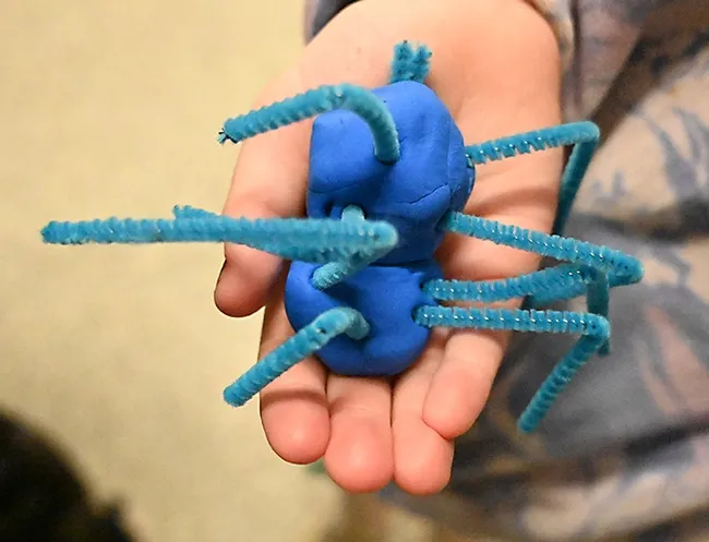 How many legs? Charlotte Baker, 6, of Davis crafted this clay model at the Bohart Museum open house on "Many-Legged Wonders." (Photo by Kathy Keatley Garvey)