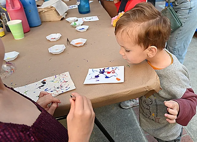 Watson Owens, 2, of Carmichael, watches a maggot crawl on his Maggot Art project. His father, Sean Owens, is a UC Davis alumnus. (Photo by Kathy Keatley Garvey)