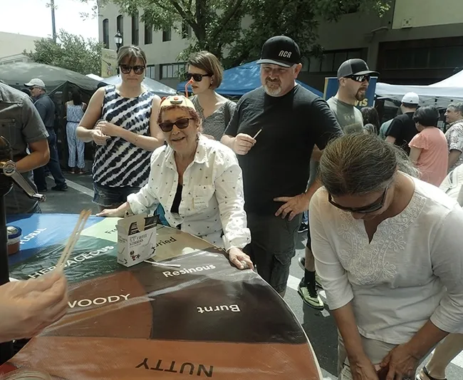 Amina Harris, director of the UC Davis Honey and Pollination Center, encourages visitors to taste honey. (Photo by Kathy Keatley Garvey)