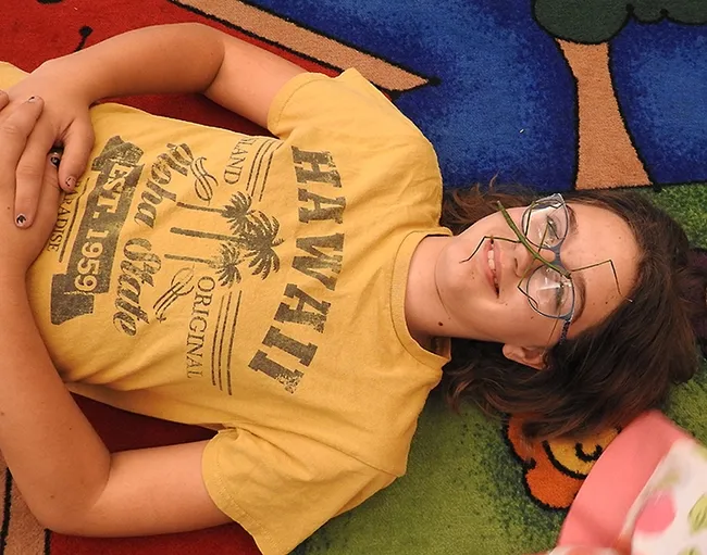 Grace Murray, 13, relaxing with a stick insect. Her mother, Kristen Murray, is a children's librarian. (Photo by Kathy Keatley Garvey)