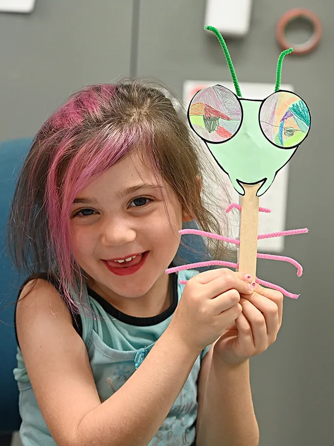 The finished product! Soraya Qaqunah holds up her Mantis on a Stick and is ready to take it home. (Photo by Kathy Keatley Garvey)