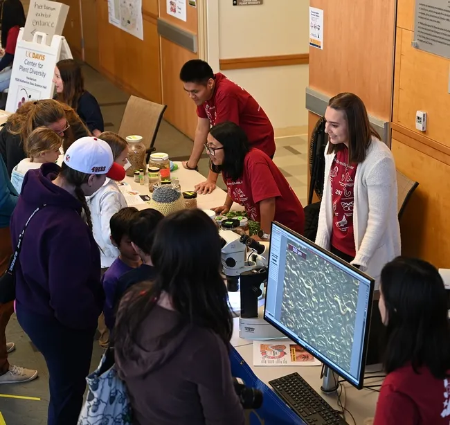 Talking to the attendees are (back, from left) doctoral student Nick Latina, Plant Pathology; and doctoral candidates Pallavi Shakya and Alison Blundell, Plant Pathology. (Photo by Kathy Keatley Garvey)