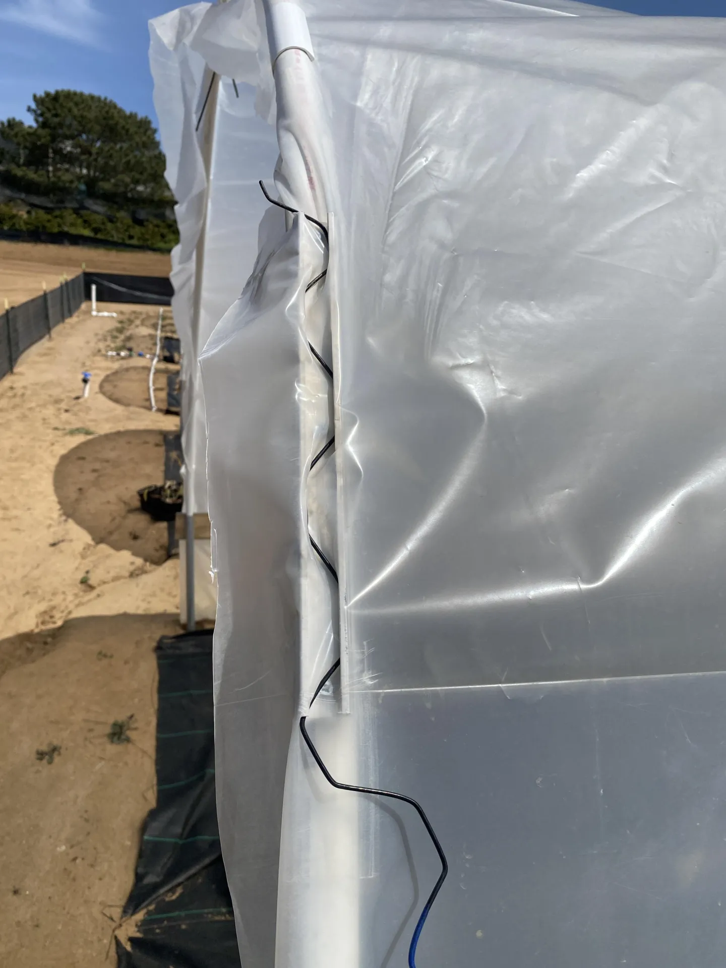 Figure 12. One-foot sections of metal lock channel and wiggle wire were cut and installed on either side of the PVC hoop to help secure the plastic.