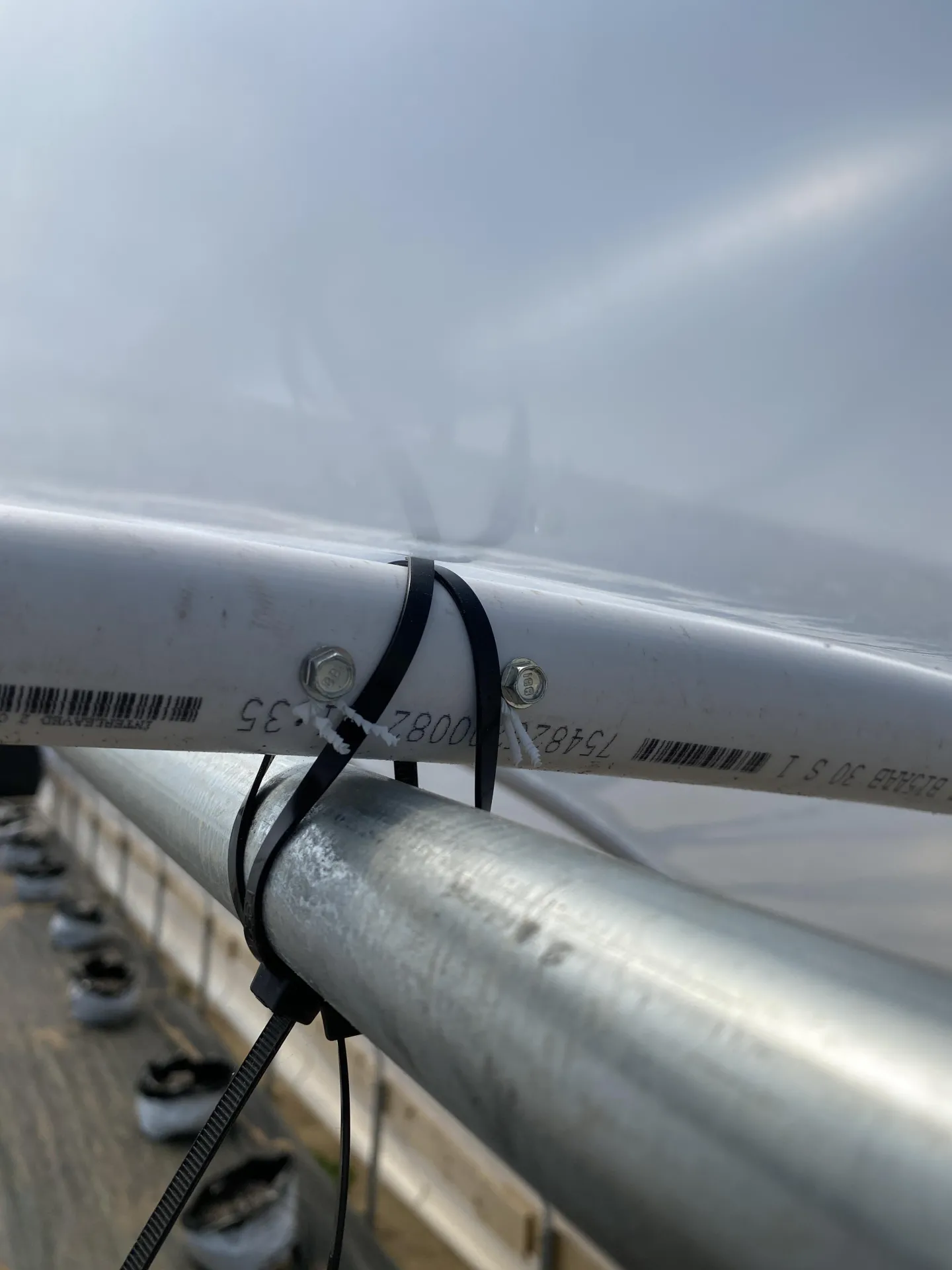 Figure 10. Self-tapping screws were placed on either side of the crossed cable ties holding the ridgepole to prevent the cable ties from moving and al