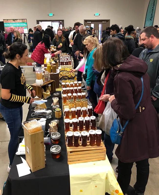 "Queen Bee" Inna Eyrih of Hawaiian Honey AT&S offers honey samples to attendees. (Photo by Kathy Keatley Garvey)