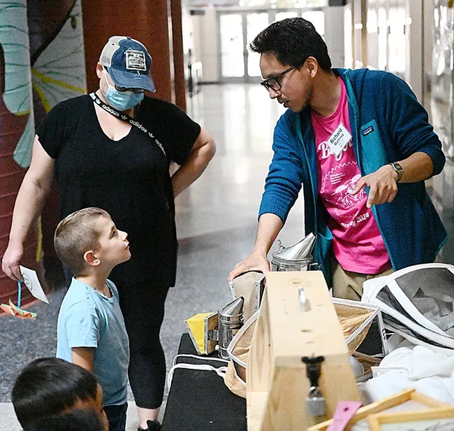 A very focused youngster asks UC Davis graduate student Richard Martinez a question about honey bees at the Bohart Museum of Entomology open house. (Photo by Kathy Keatley Garvey)