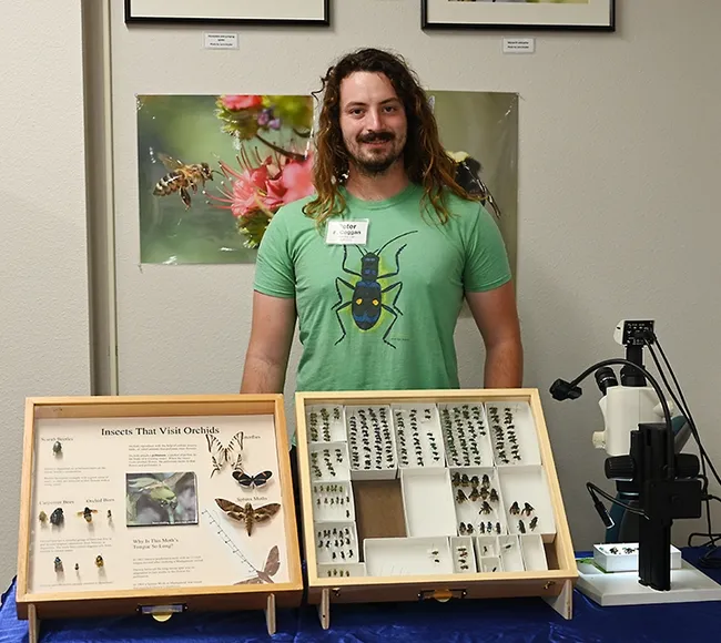Doctoral student Peter Coggan of the laboratory of Santiago Ramirez, is ready for the crowd to arrive. Coggan studies the neurological and genetic basis of orchid bee courtship behavior and evolution. (Photo by Kathy Keatley Garvey)