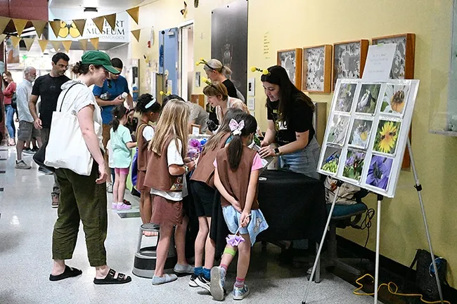 UC Davis Health physician Jaclyn Watkins (far left), co-leader of Brownie Troop 121 of Davis, watches as troop members listen to doctoral candidate Lexie Martin of the Rachel Vannette lab. The girls earned their Brownie Bug Badges. (Photo by Kathy Keatley Garvey)