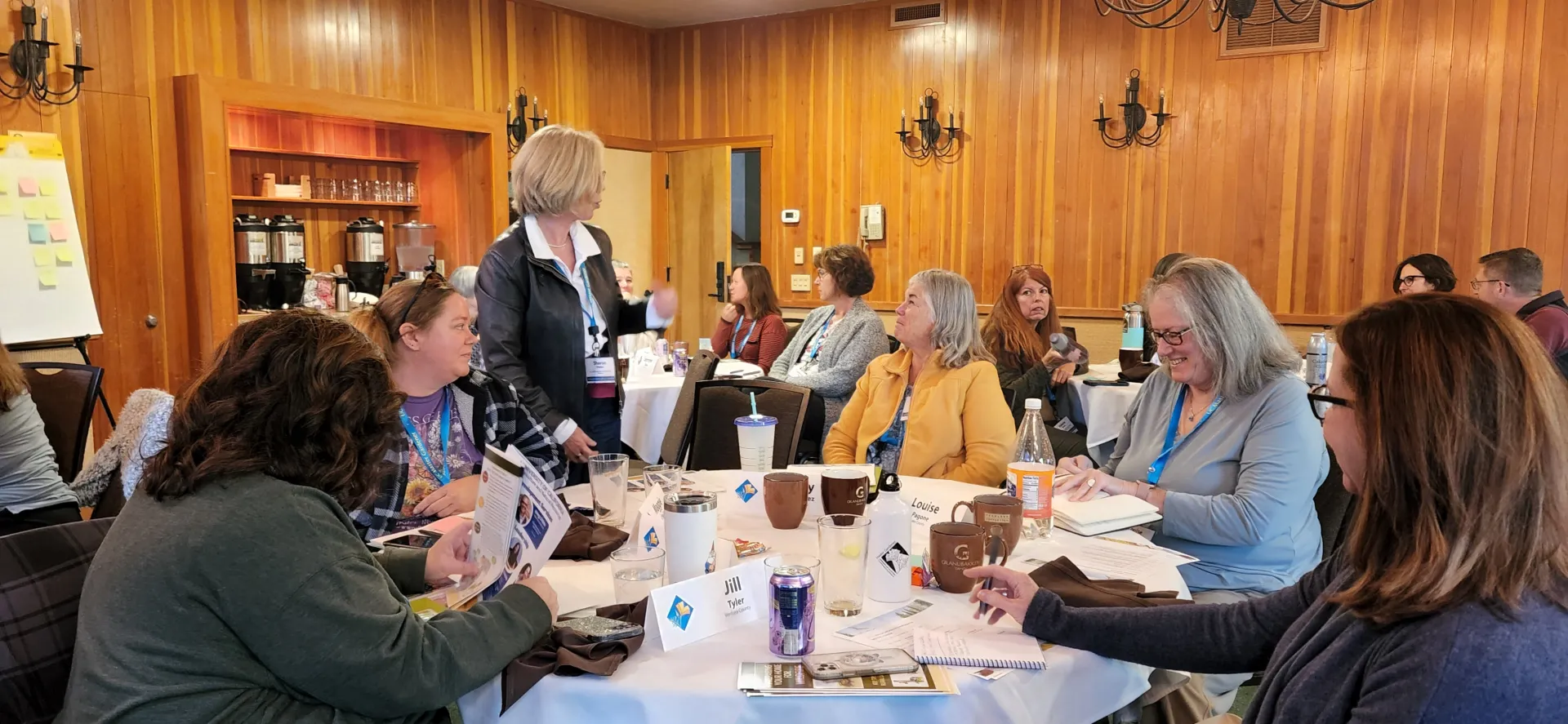 Volunteers sitting around tables talking at an event