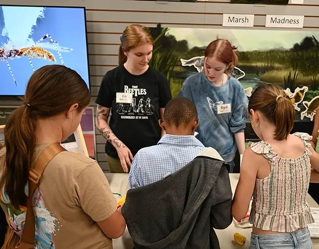 UC Davis entomology doctoral student Emma "Em" Jochim (left) and high school intern Syd Benson engage the youngsters. (Photo by Kathy Keatley Garvey)