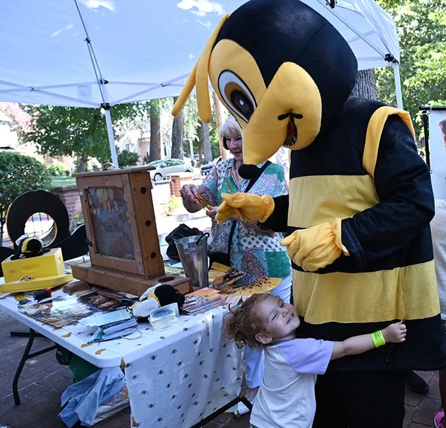 Little Eloise Vieira loved The Honey Bee. In back is Vacaville Museum Guild member is bee assistant Sharon Walters. (Photo by Kathy Keatley Garvey)
