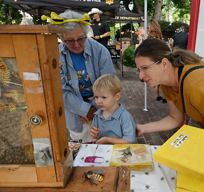 Beekeeper Ettmarie Peterson (right) discusses bees with Damian Strzelczyk, 3, and his mother, Marta Strzelczyk. (Photo by Kathy Keatley Garvey)