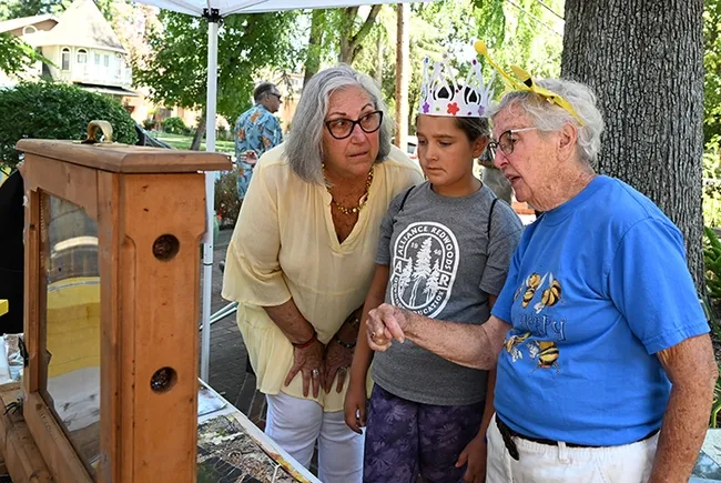 Emeline Swank and her grandmother Maryann Henn (far left), a member of Museum Guild, learn about bees from beekeeper Ettamarie Peterson. (Photo by Kathy Keatley Garvey)