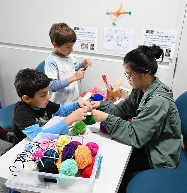 Isaiah Sahakian Frenz and his brother, Levon Sahakian Frenz, mastering the art of making a colorful spider web. (Photo by Kathy Keatley Garvey)