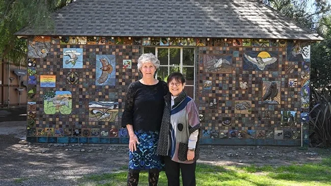 UC Davis distinguished professor emerita Diane Ullman (left) and Gale Okumura, lecturer emerita, Department of Design, stand in front of their project, "A Bird's Eye View," at the California Raptor Center. (Photo by Kathy Keatley Garvey)