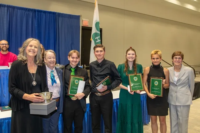 CA 4-H and coach with their awards. They are standing with Dr. Bradley and Dr. Hall.