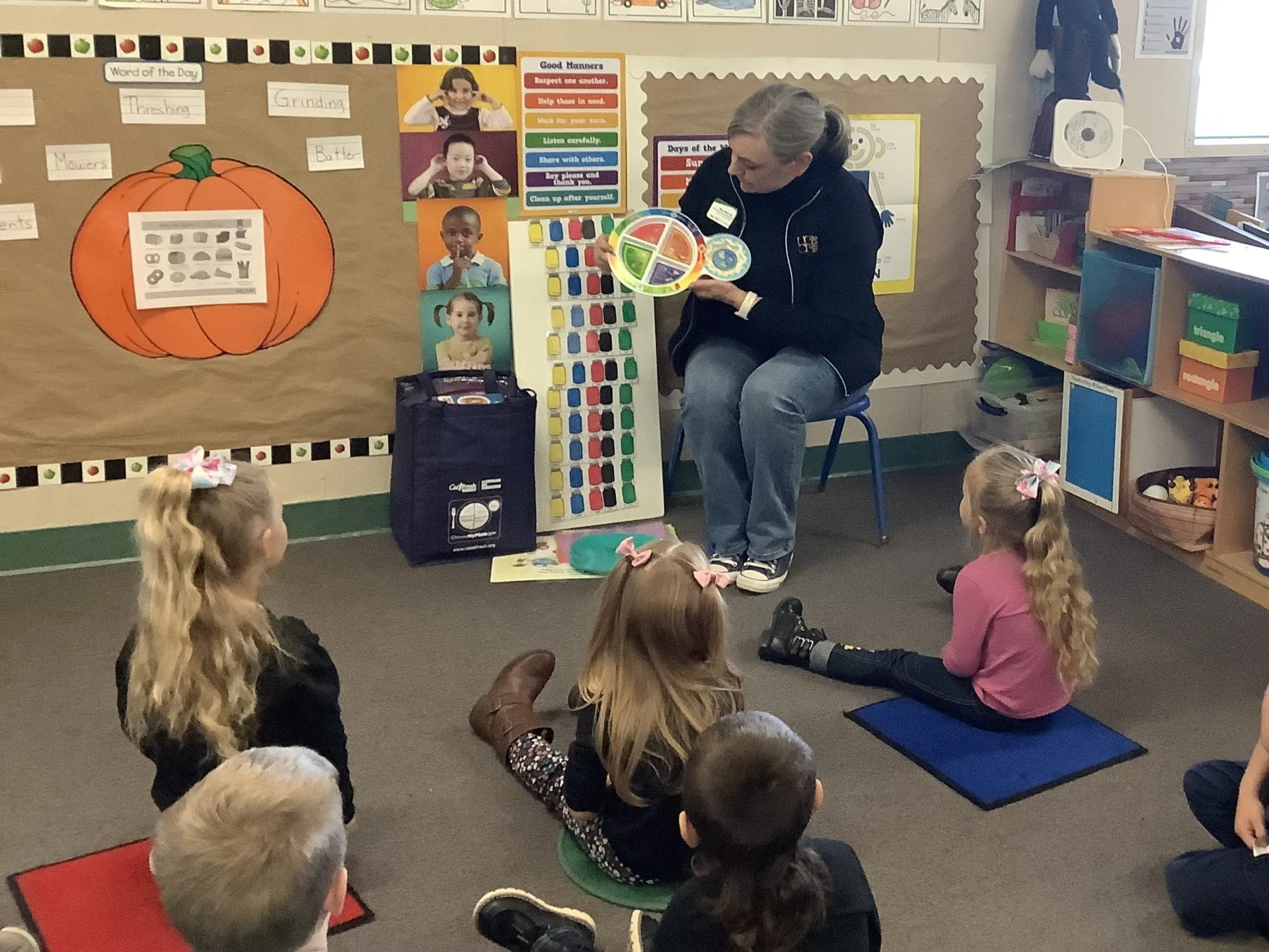 An educator demonstrations food portions for preschoolers using MyPlate