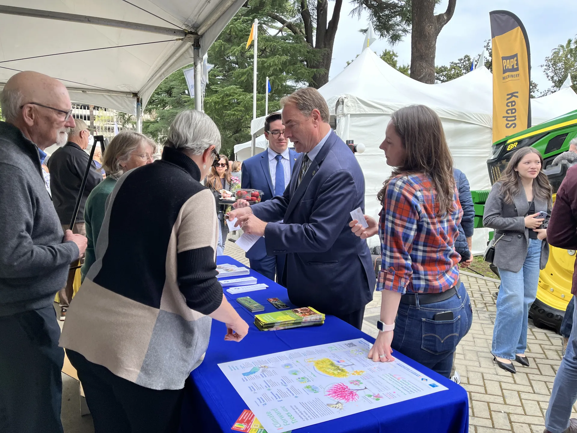 Three Master Gardener volunteers talk with the assemblymember as Anne Megaro listens.