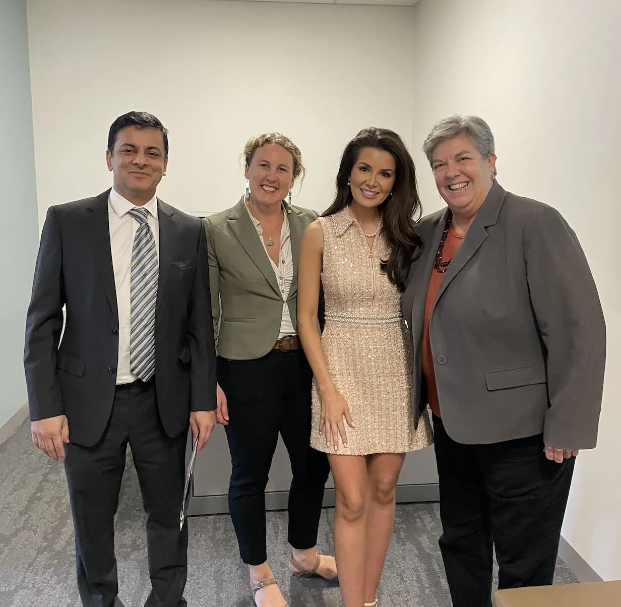 Four people stand in a row