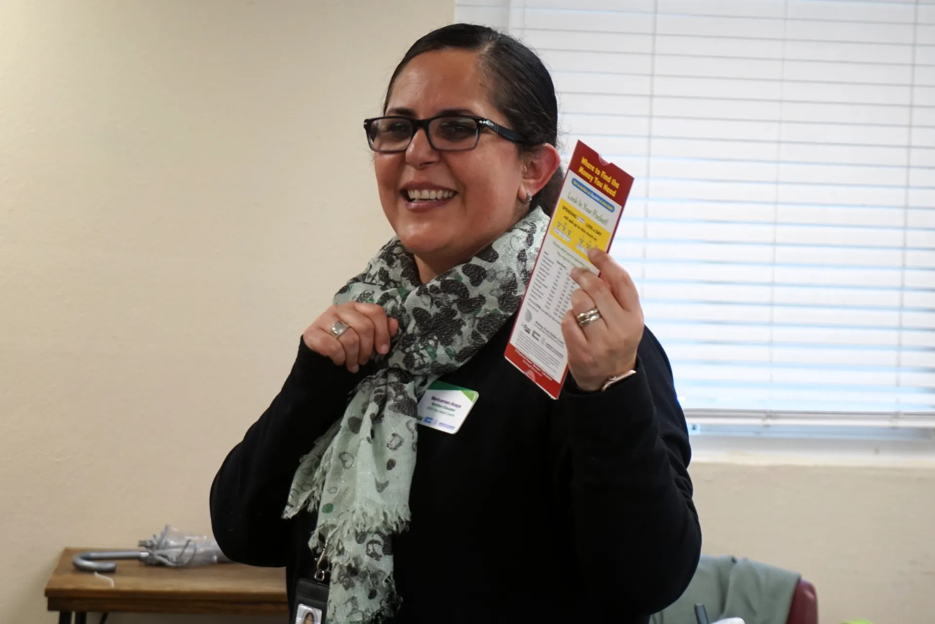 Maricarmen Anaya holds up the "calculator" of potential savings by not spending money on items such as cafe-bought coffee and fast food meals.