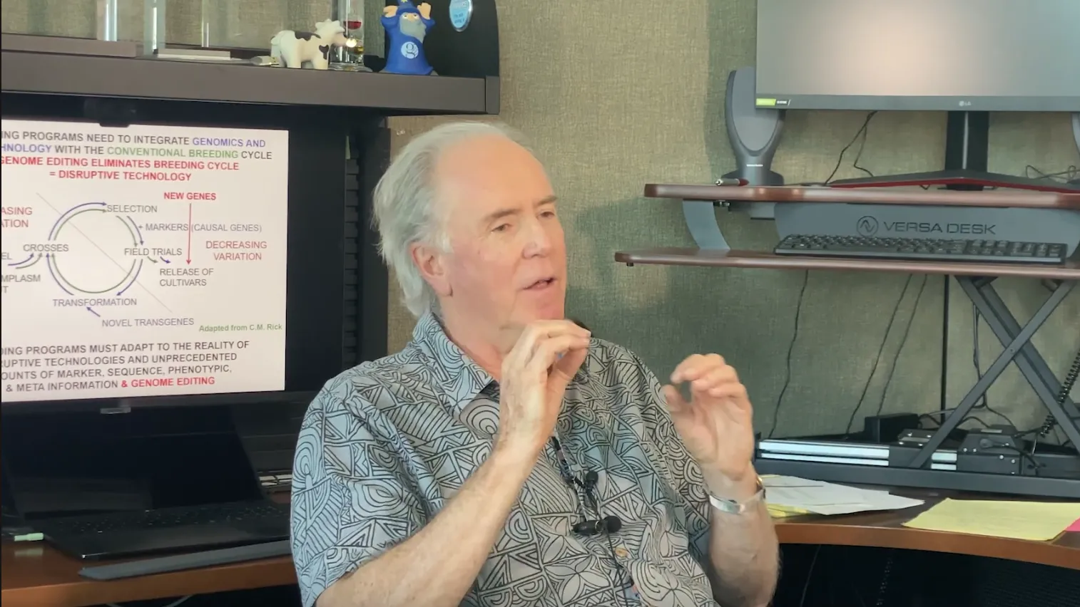 Richard MIchelmore sits at his desk speaking to someone off-camera