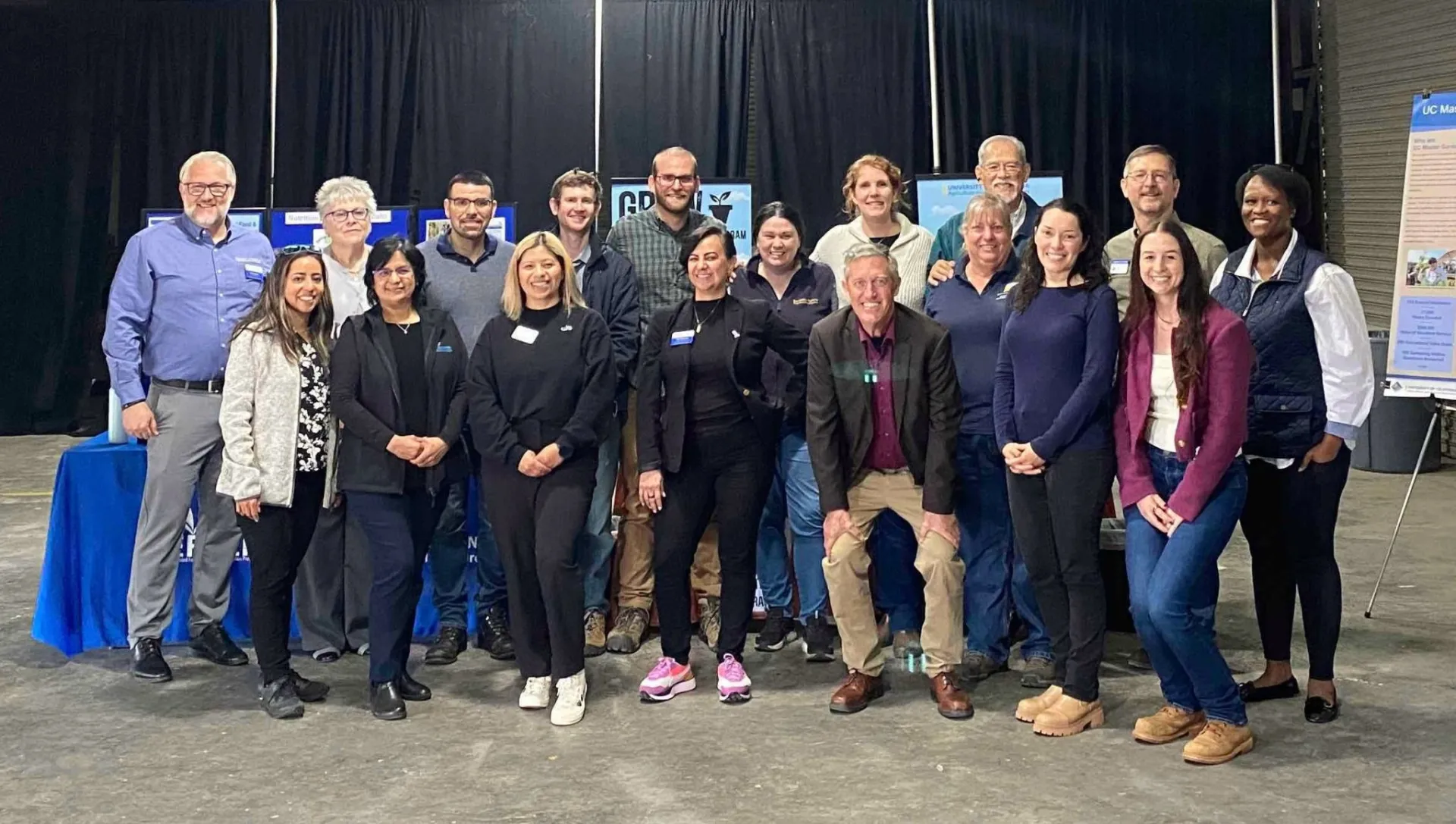 Nineteen people stand in 2 rows