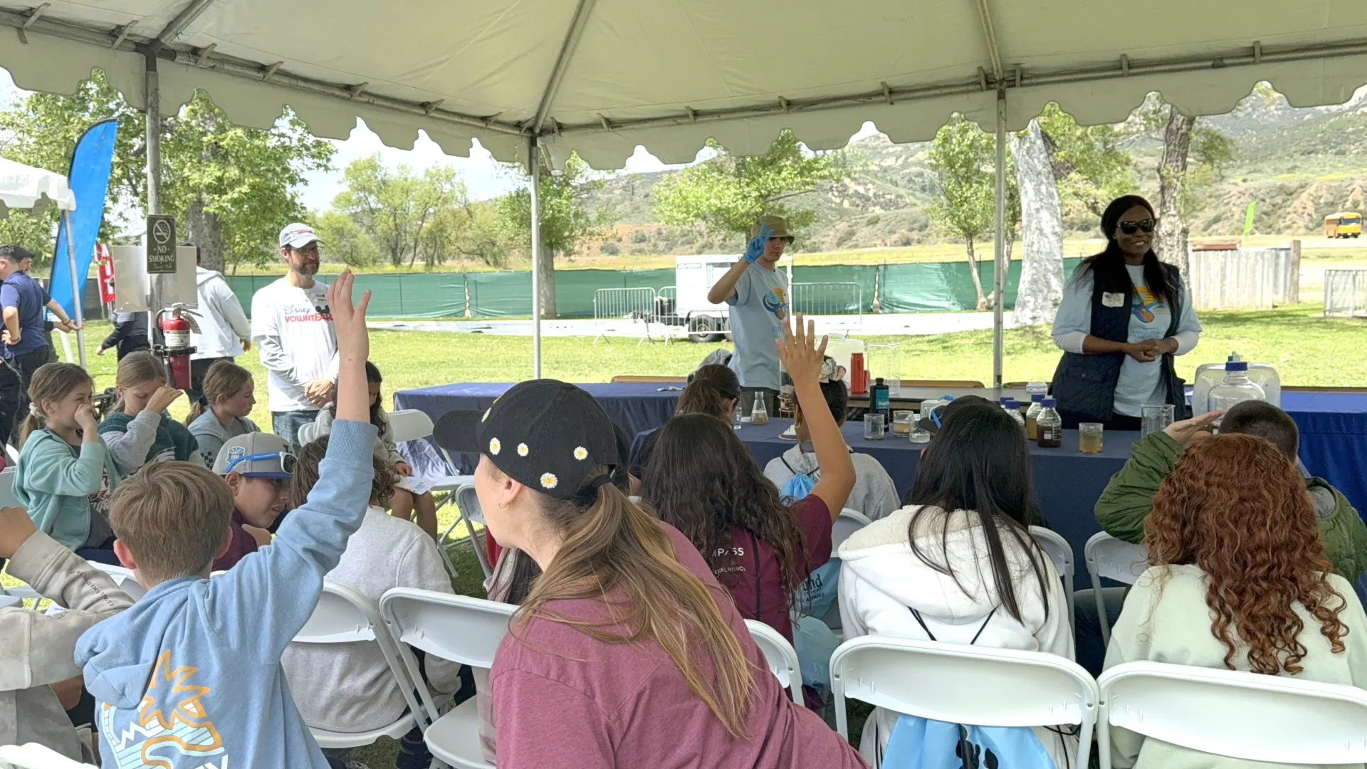 Educators talk students through water filtration processes at a park