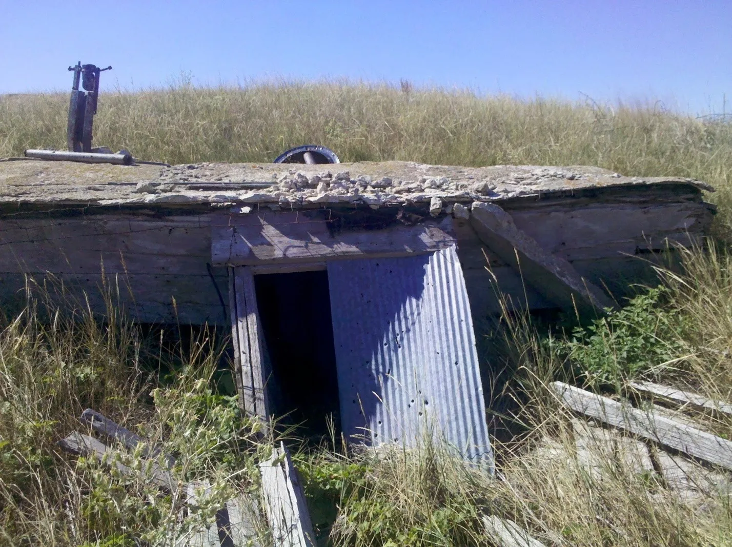 Root cellar in the center of a grassy field. 