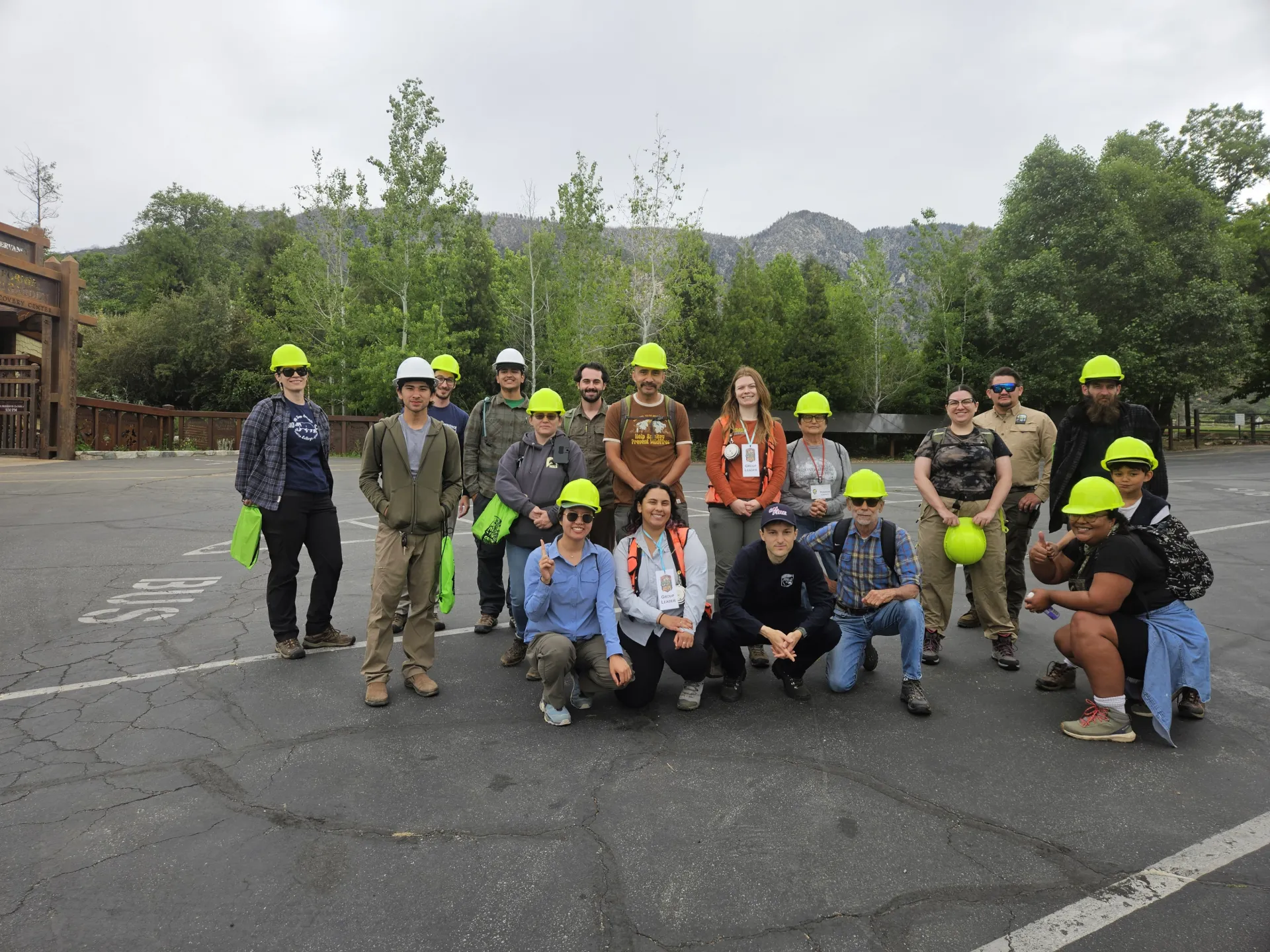 A group photo of people wearing green hardhats.