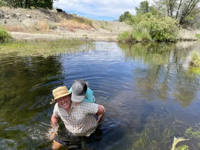 Cleo Woelfle Hazard and his child visit a beaver dam analog built by the Scott River Watershed Council (with some assistance from local beavers) during a research trip in 2022. Michael Hsu's article on him won a gold award in the ACE competition. (Photo by Daniel Sarna-Wojciki)