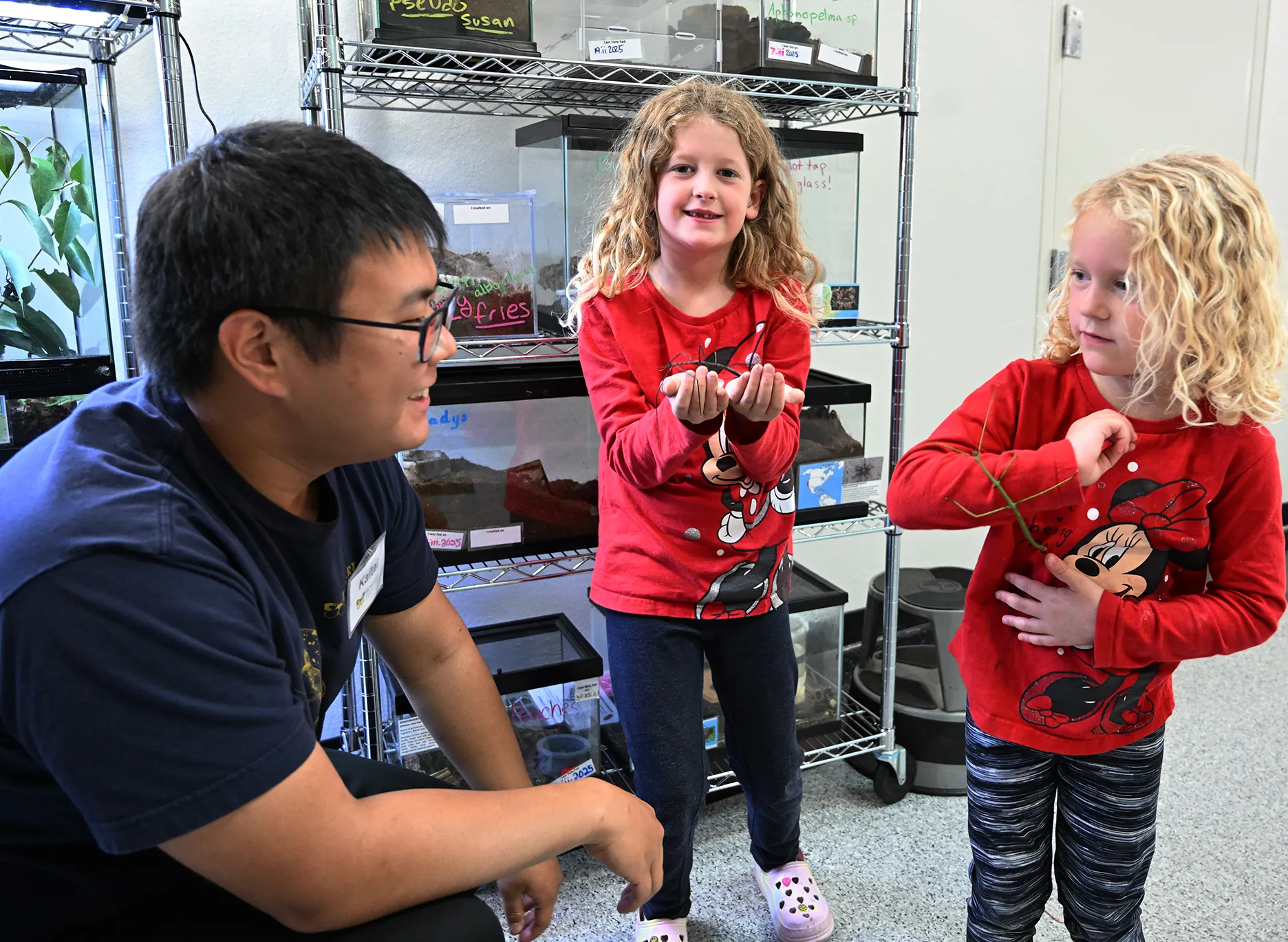 Entomologist Kaitai Liu talks to sisters Aria Messer, 7, and her sister Ava Messer, 5, of Dixon. Their mother, Nicole Meenan, is a UC Davis alumna. (Photo by Kathy Keatley Garvey)