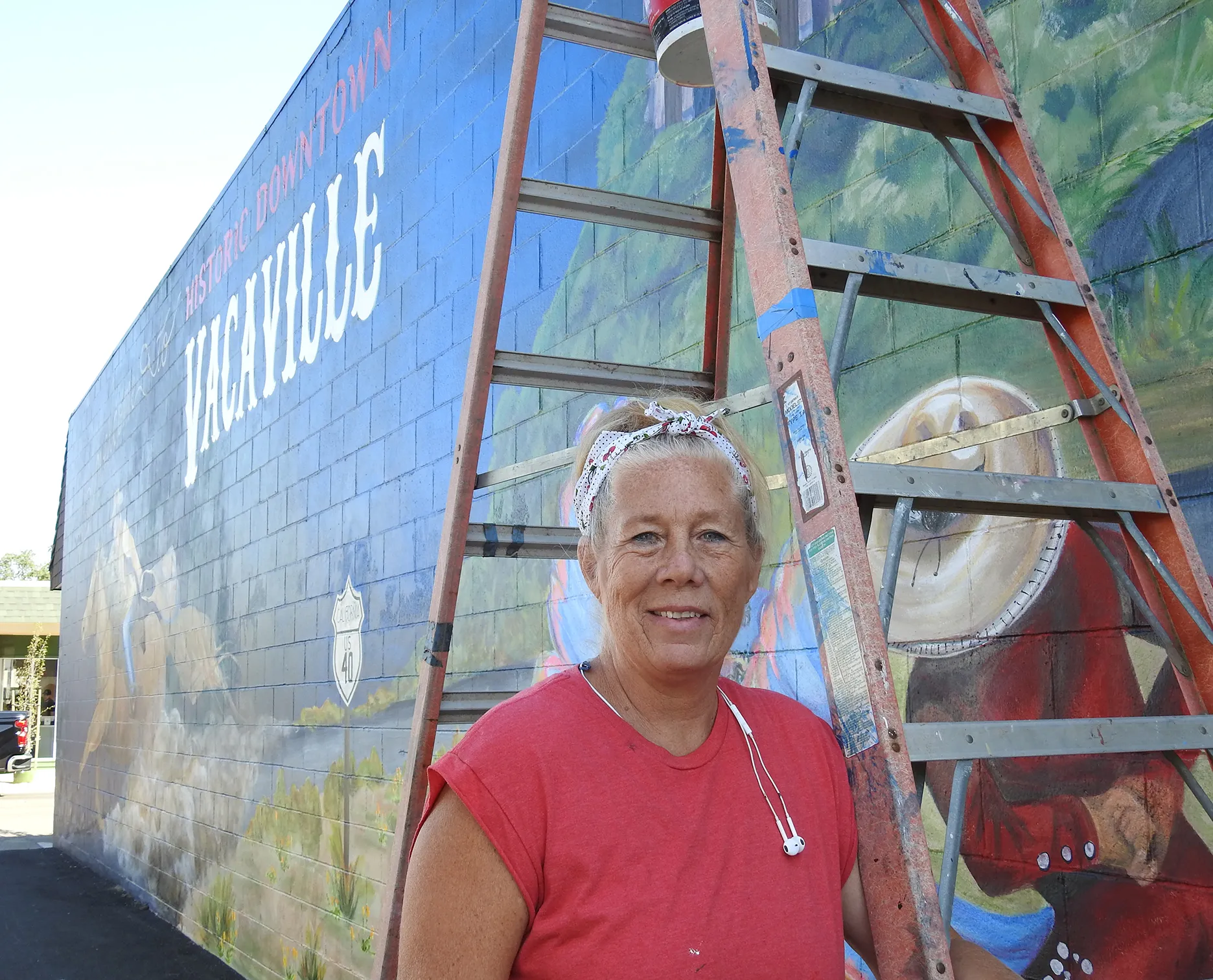 Joi McNeil stands in front of her mural. (Photo by Kathy Keatley Garvey)