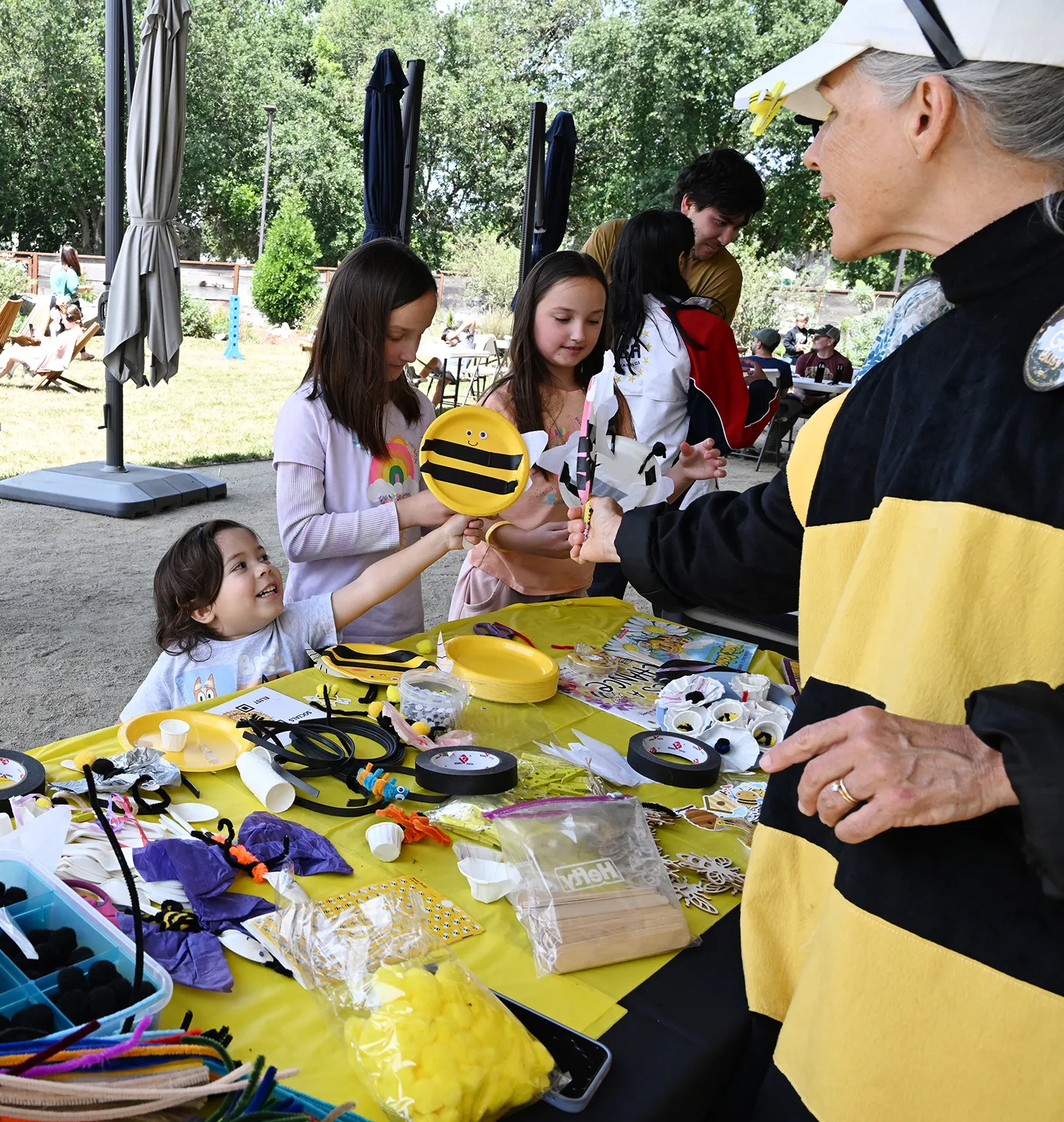 Children love CAMBP's arts and crafts table. At right is Wendy Mather, CAMBP co-program manager as Bettina the Bee. (Photo by Kathy Keatley Garvey)