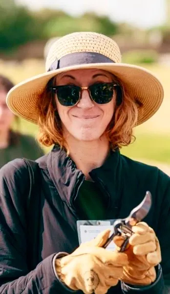 Master Gardener holding pruning sheers and smiling.