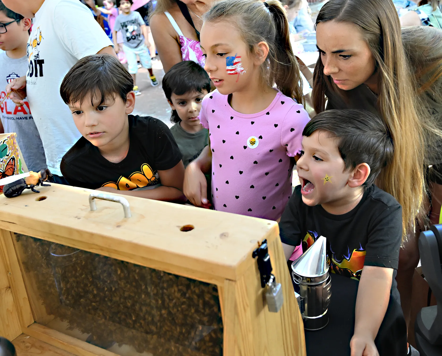 The Harvey family locates the queen bee. From left are Braxton Harvey, Avery Harvey and Cooper Harvey with mother Kala Harvey. (Photo by Kathy Keatley Garvey)