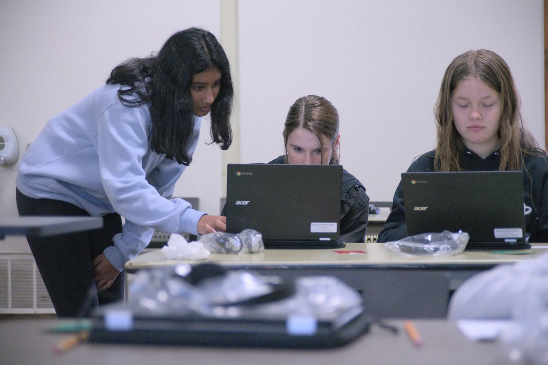 Three young people work on laptops
